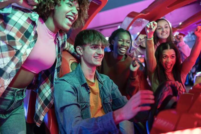A group of people joyfully riding in a car, celebrating a fun zone birthday party together.