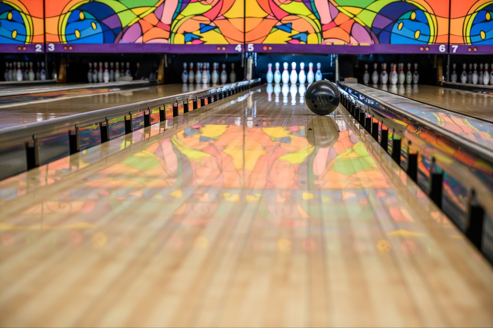 A bowling ball on a bowling lane, set for an epic night out of bowling and laser tag at a laser tag arena