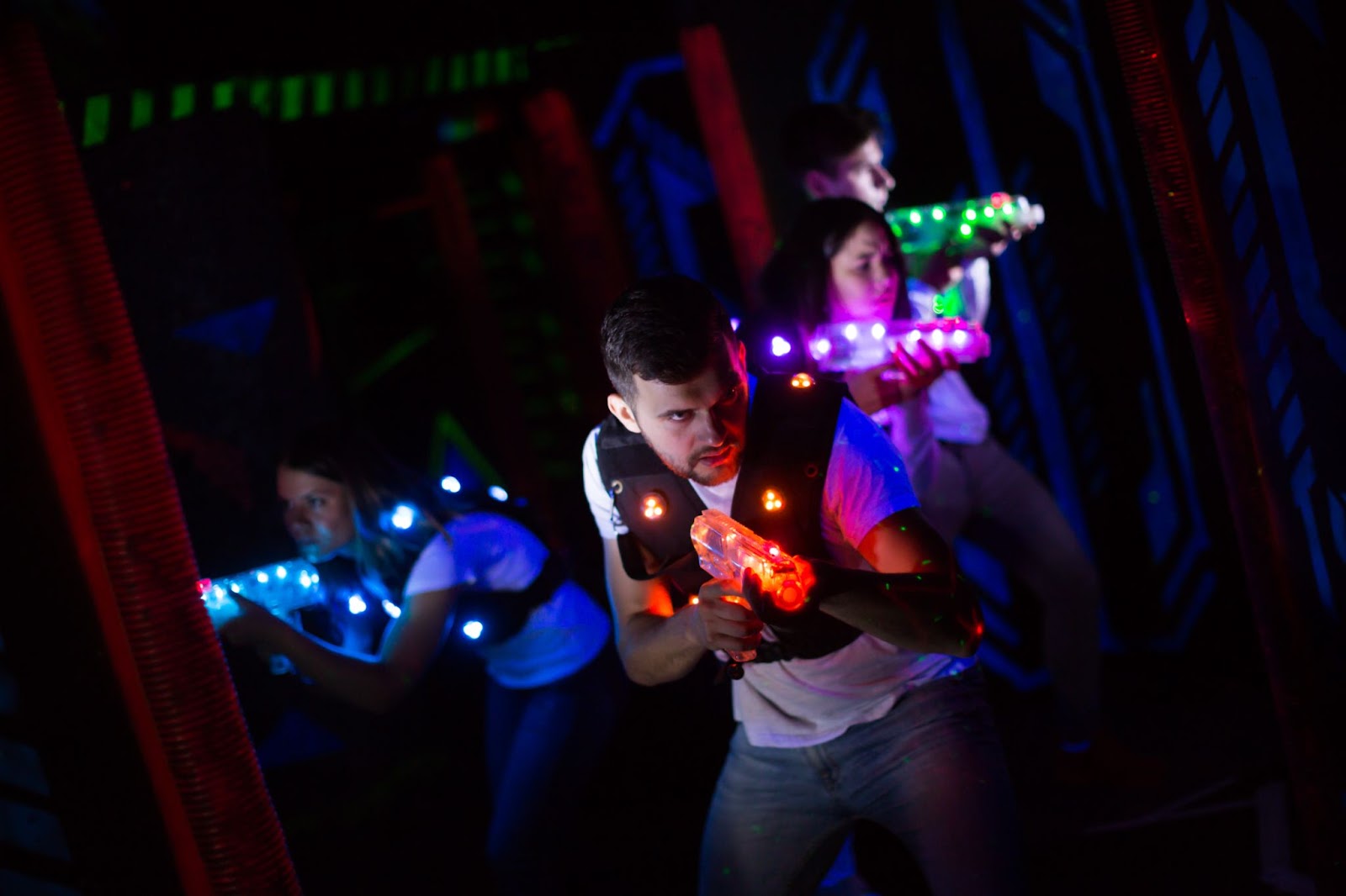 A vibrant group having fun with glow sticks during an epic night out at a bowling alley or laser tag arena