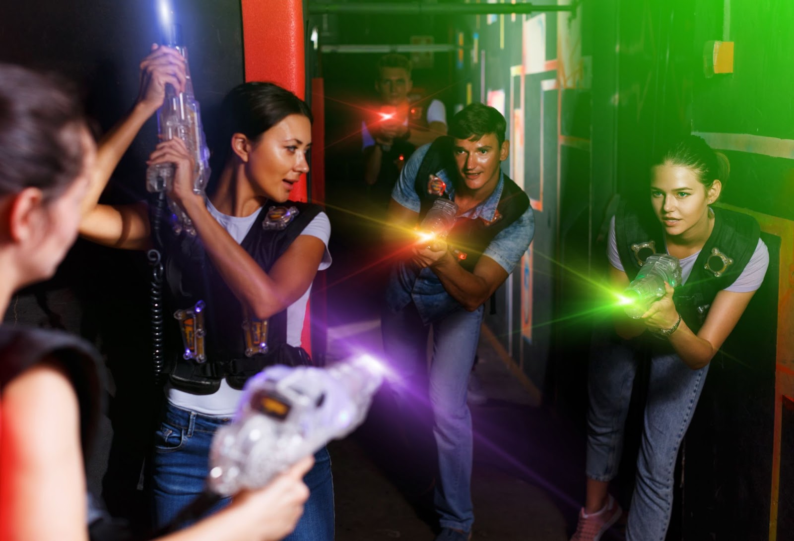 Friends having fun playing with laser tag equipment and guns